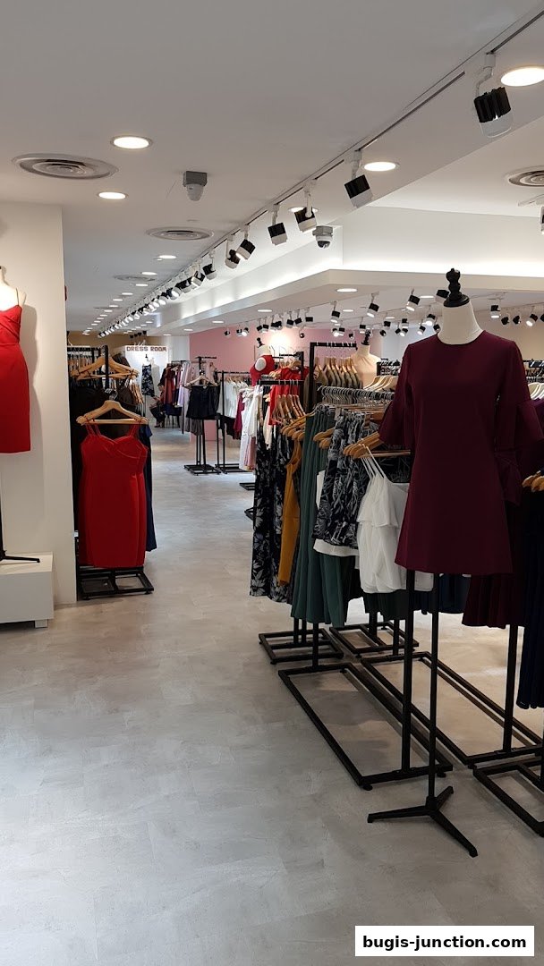 Interior view of a clothing store with racks of dresses and apparel on display.