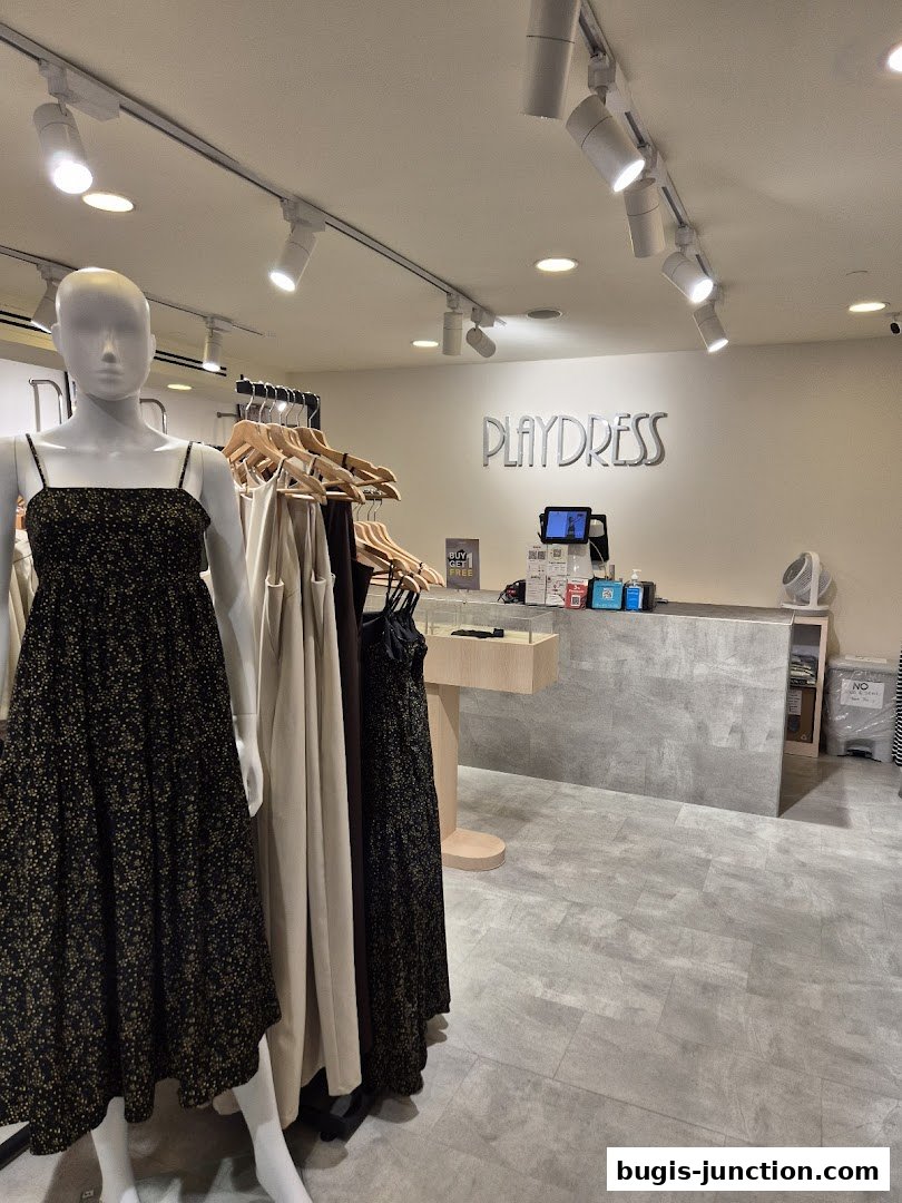 Interior of Playdress clothing store with mannequins and dresses on display.