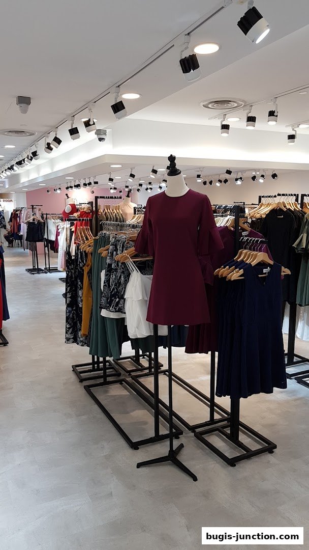 Interior view of a clothing store with mannequins and racks of dresses.