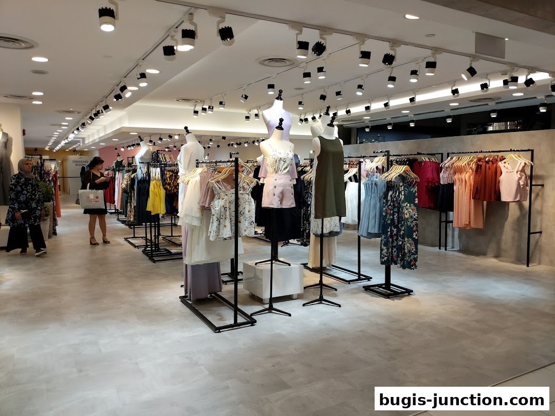 Interior view of a clothing store with mannequins and racks of dresses.