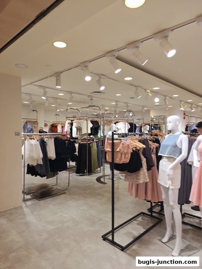 Interior view of a clothing store with racks of apparel and mannequins.
