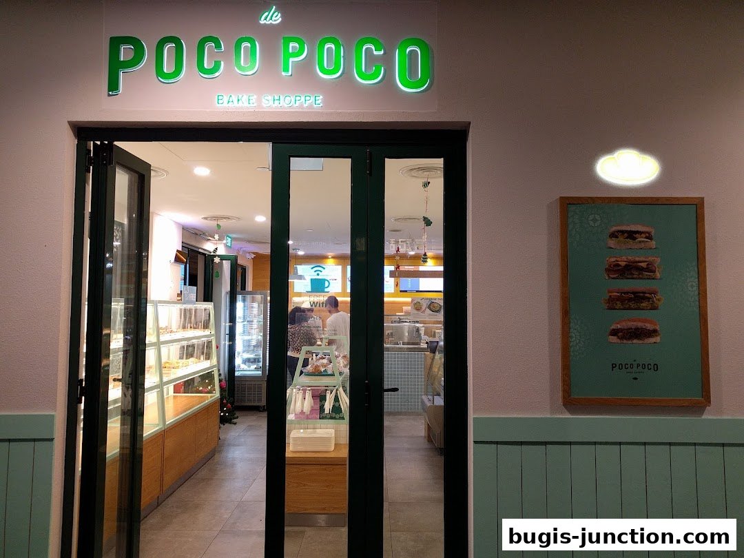 The entrance of Poco Poco Bake Shoppe, showcasing baked goods and sandwiches.