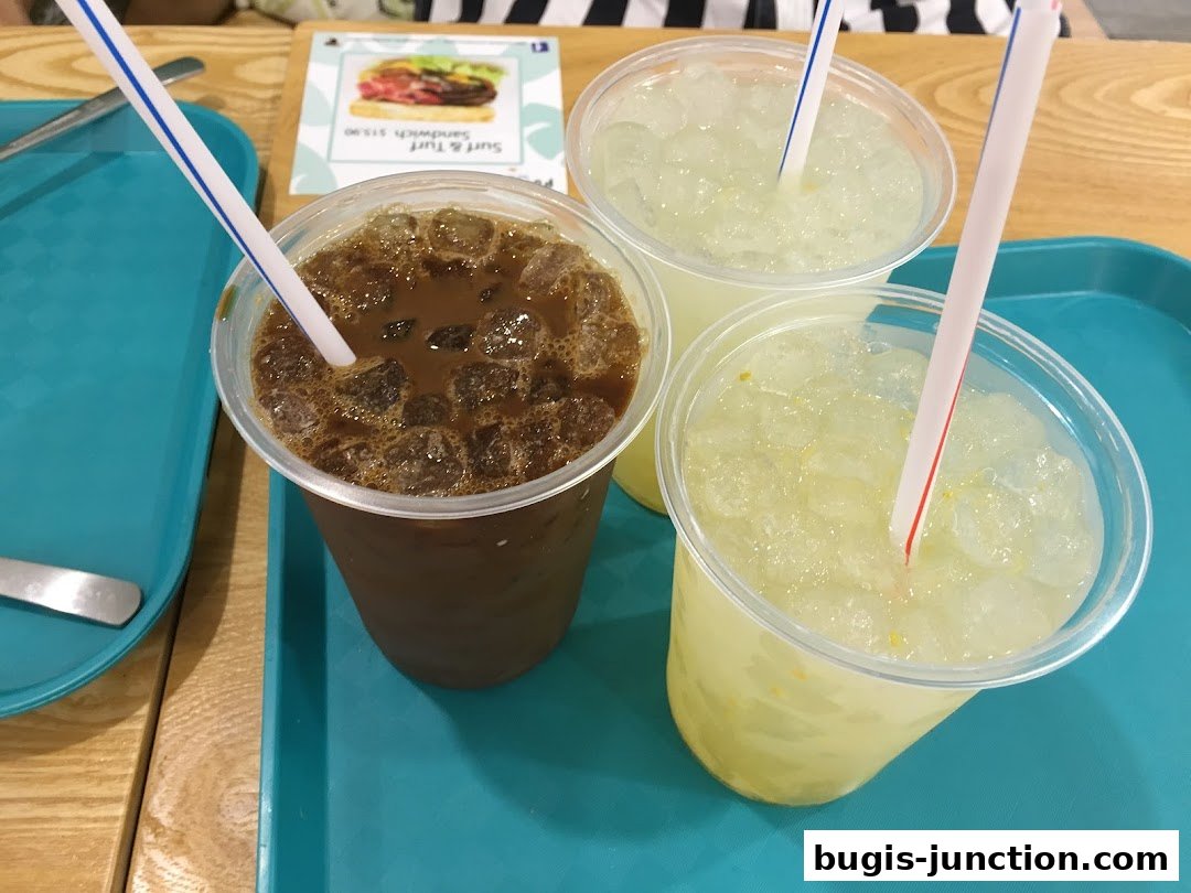 Three iced drinks, including coffee and lemonade, served on a teal tray.