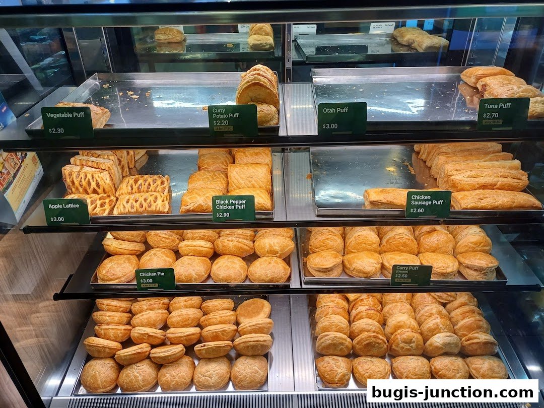 A display case filled with various savory and sweet pastries, including puffs and pies.