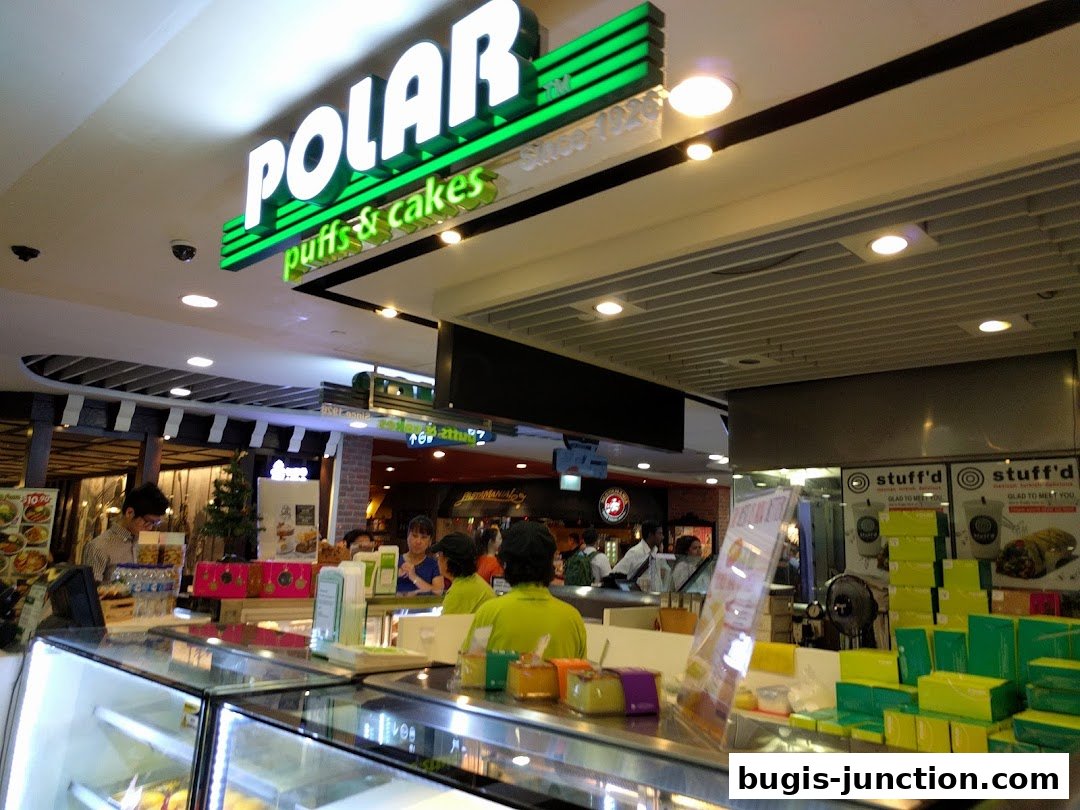 Interior view of Polar Puffs & Cakes shop with staff and display cases.