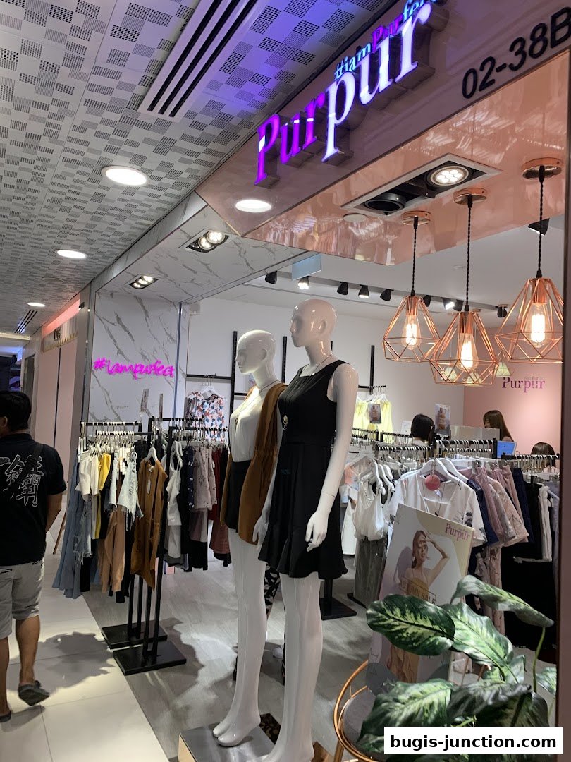 A fashion boutique with mannequins displaying outfits and racks of clothing.