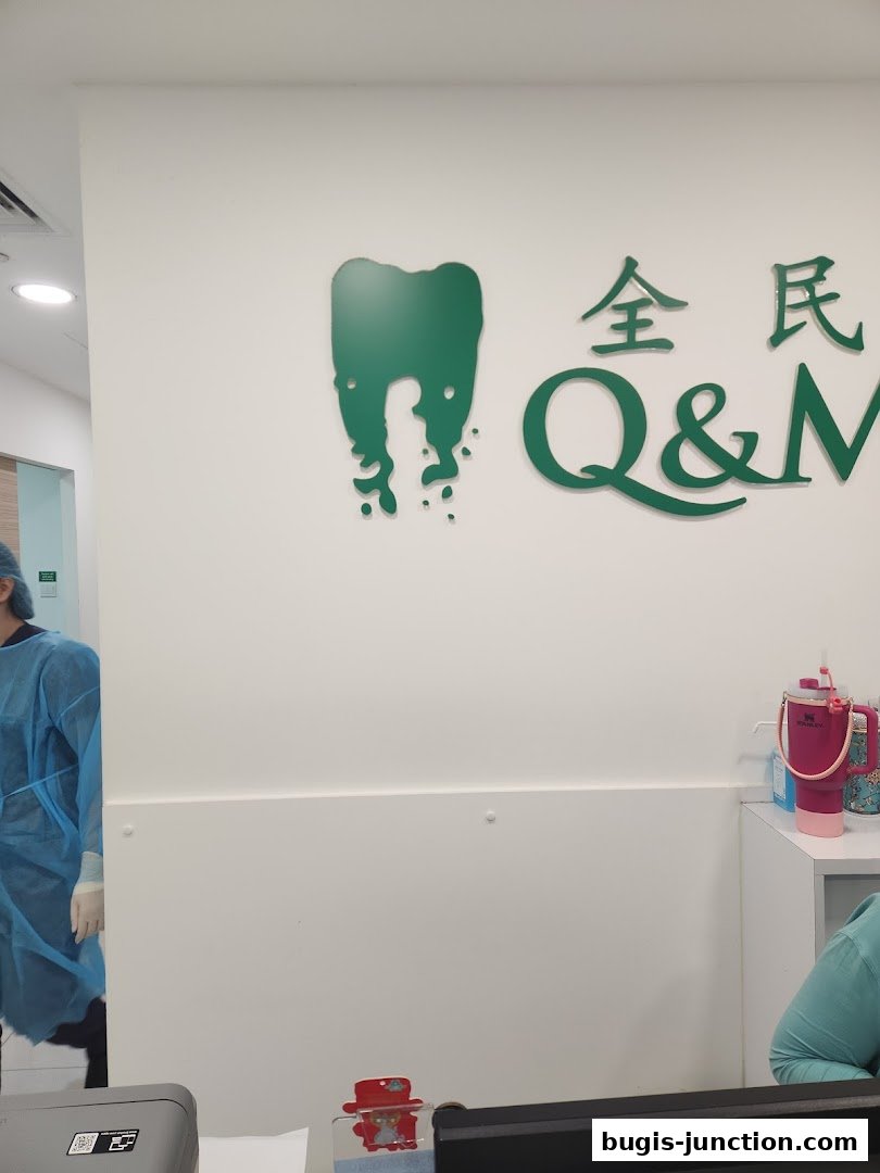Interior view of Q&M Dental Centre Bugis Junction with branding and staff.