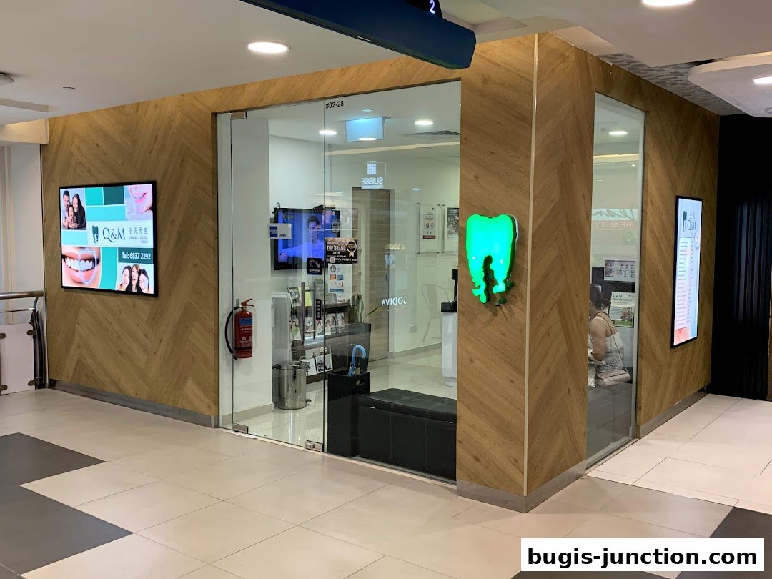 The exterior of Q&M Dental Centre Bugis Junction, featuring a modern wood-paneled facade and glass entrance.