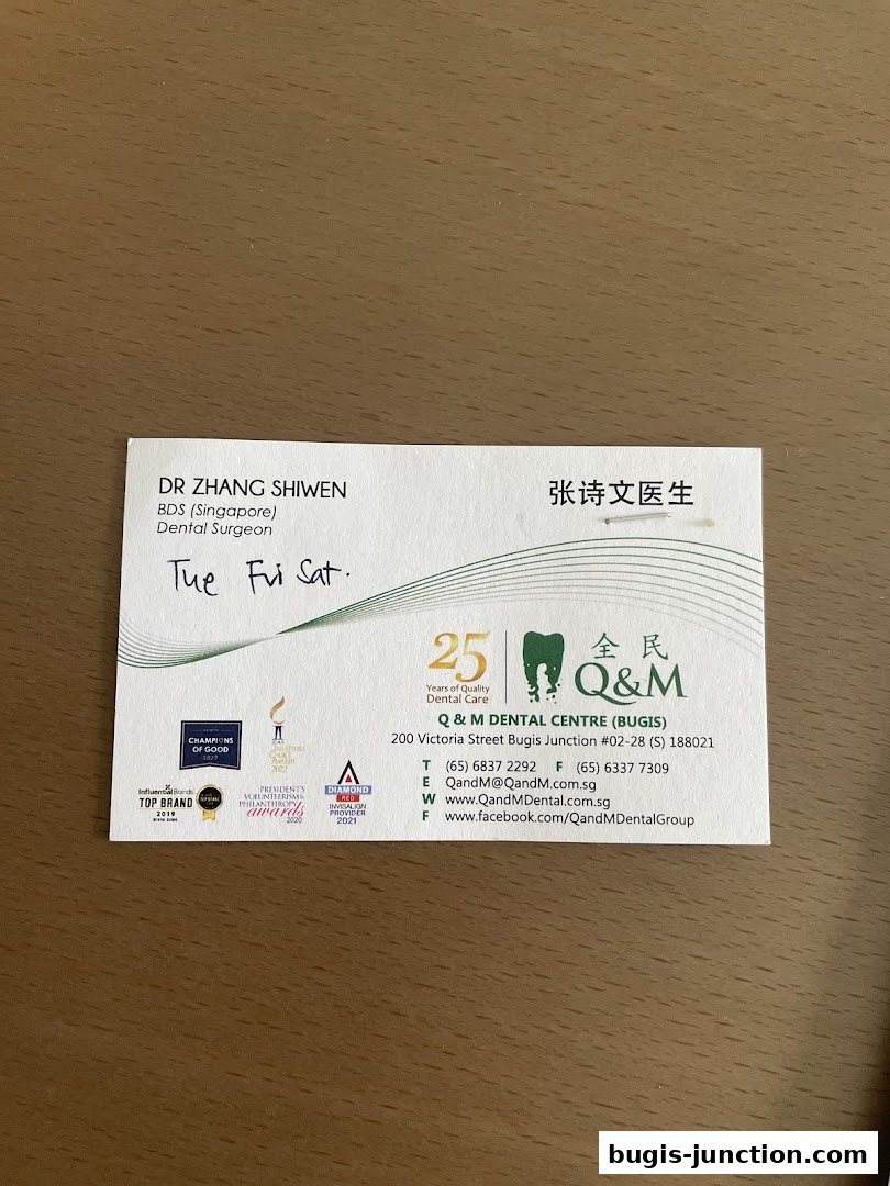 A business card for Dr. Zhang Shiwen, a dental surgeon at Q & M Dental Centre.