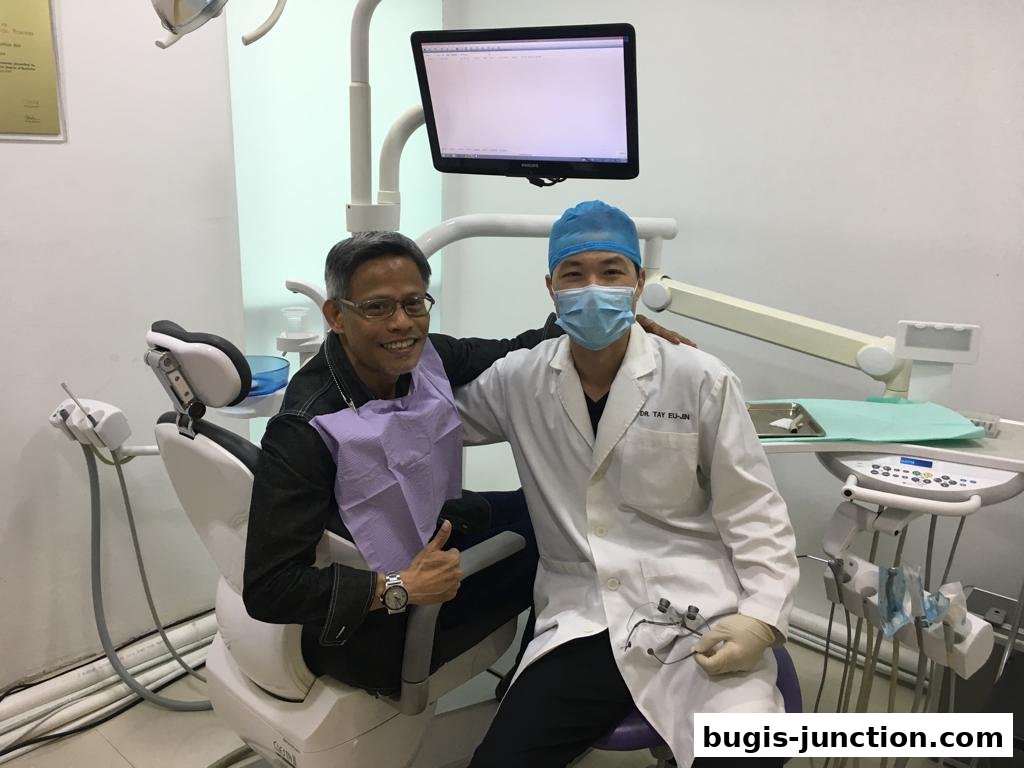 A dentist and a patient smiling in a dental clinic with dental equipment.