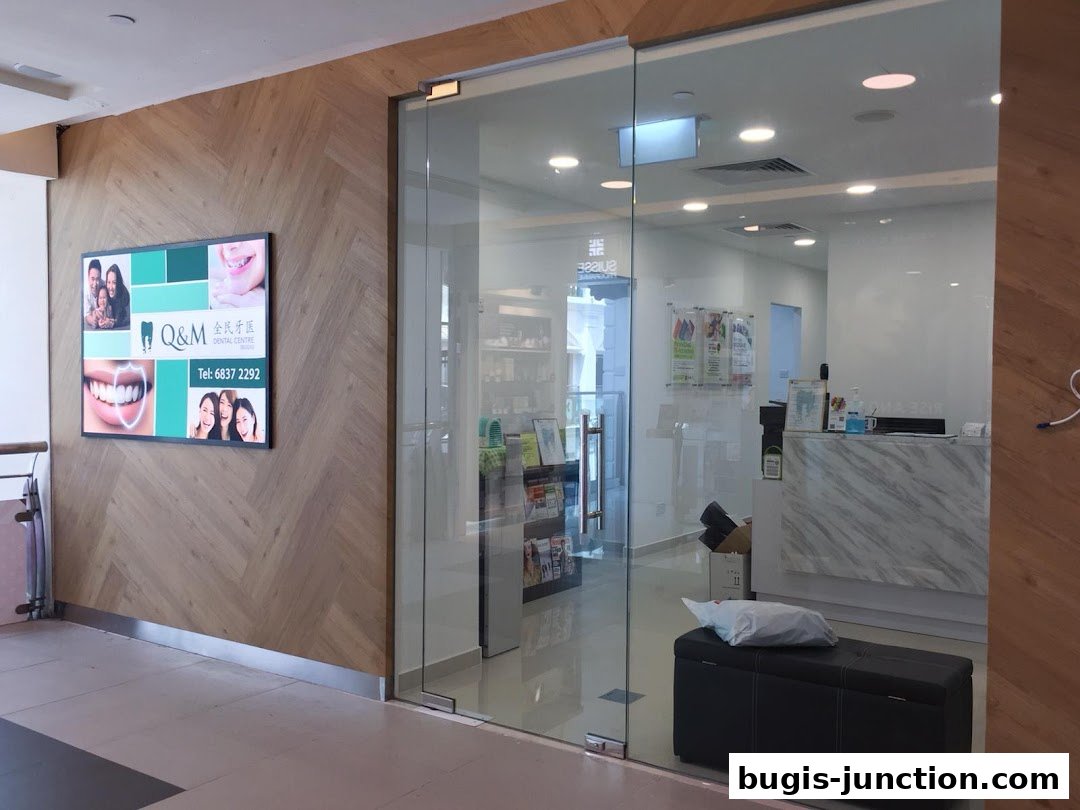 The entrance to Q&M Dental Centre Bugis Junction with a digital display and reception area visible.
