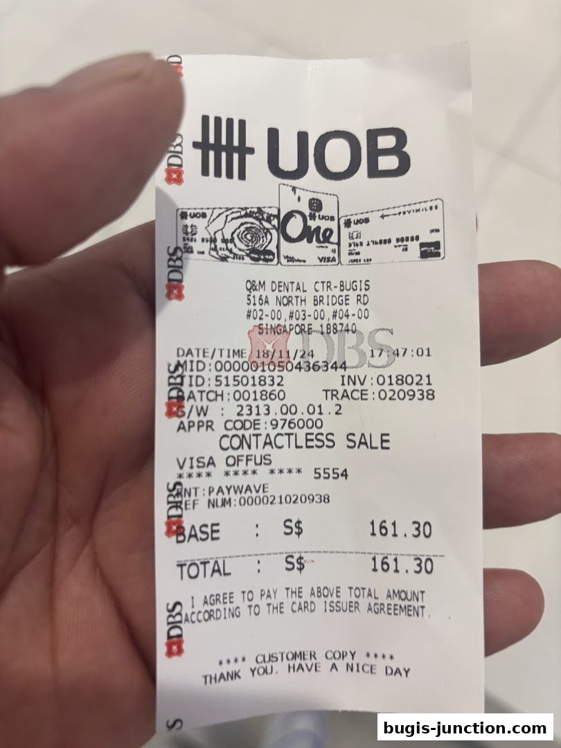 A receipt from Q&M Dental Centre Bugis showing a contactless sale transaction.