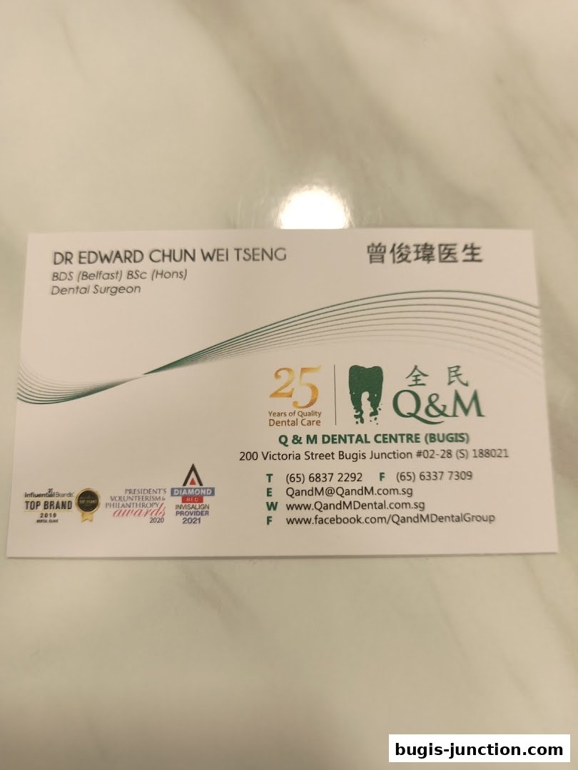 A business card for Q & M Dental Centre Bugis, featuring Dr. Edward Chun Wei Tseng.