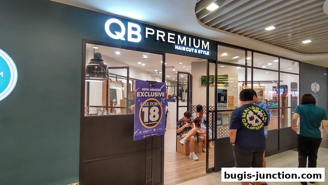 The exterior of QB Premium, a hair salon, with customers waiting inside.