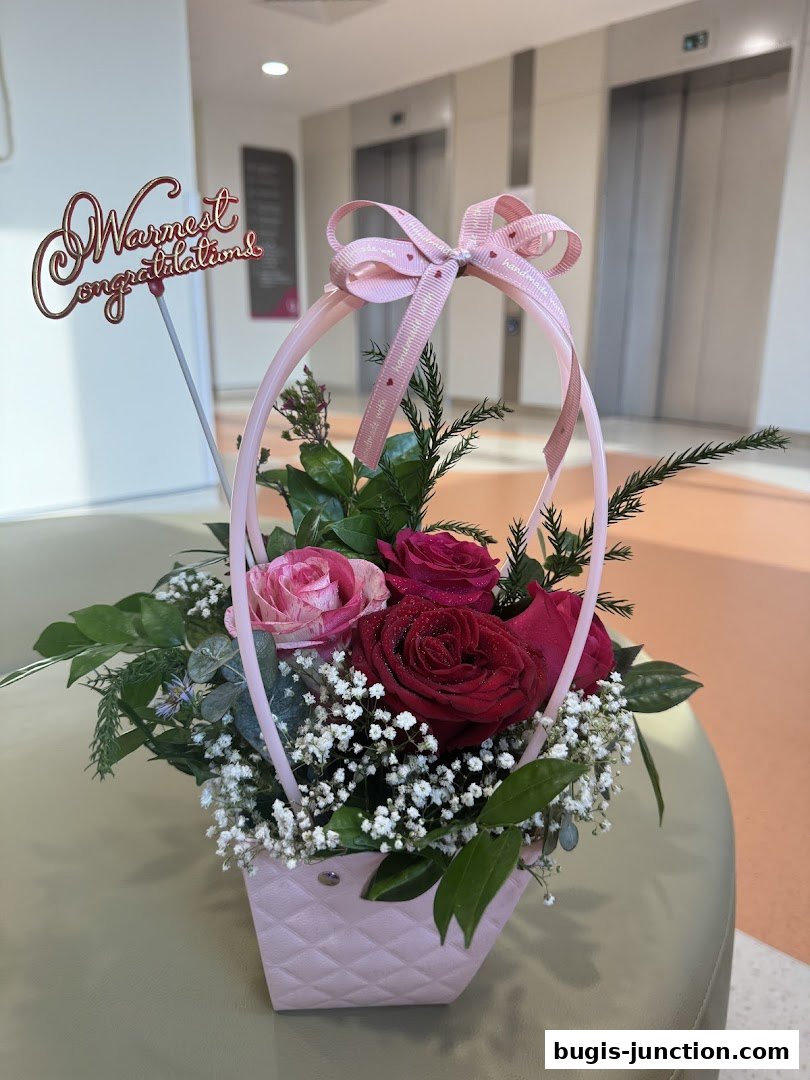 A beautiful floral arrangement in a pink basket with a 'Warmest congratulations' topper.