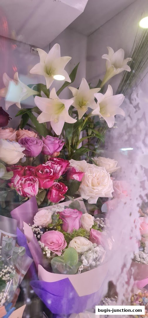 A beautiful display of white lilies and assorted roses in various shades of pink and white.