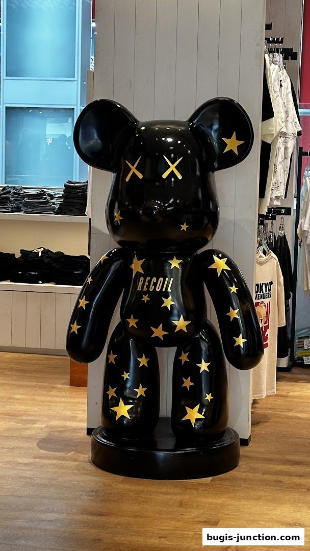 A large black bear-shaped statue with gold stars and the word RECOIL.