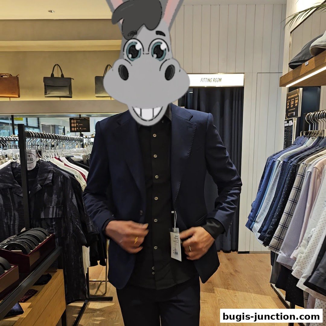 A person in a suit stands in a clothing store, surrounded by racks of shirts and accessories.