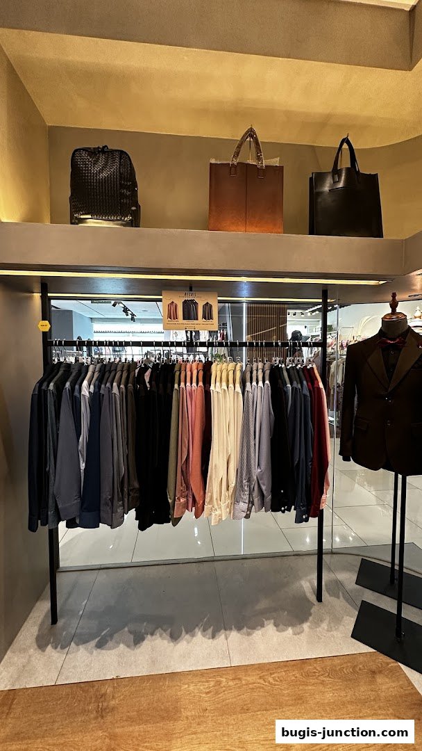 A display of men's shirts and bags in a retail store.