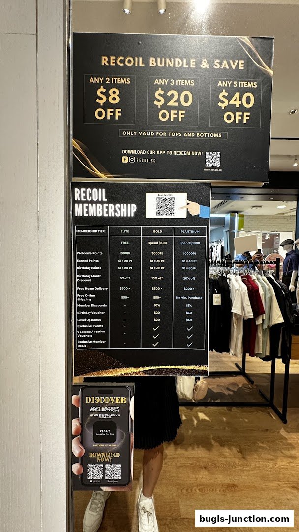 A sign displays RECOIL's bundle deals and membership benefits, with clothing racks visible in the background.