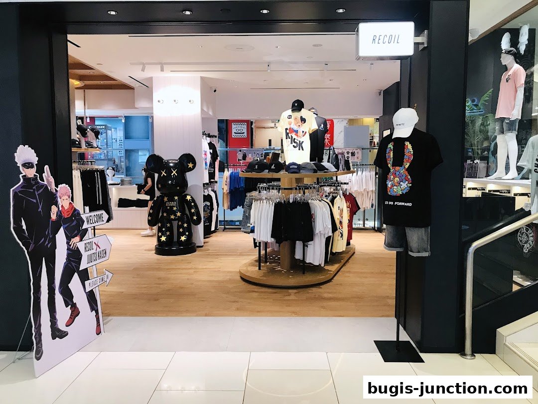 The entrance of RECOIL shop featuring anime characters, clothing displays, and a large bear figure.
