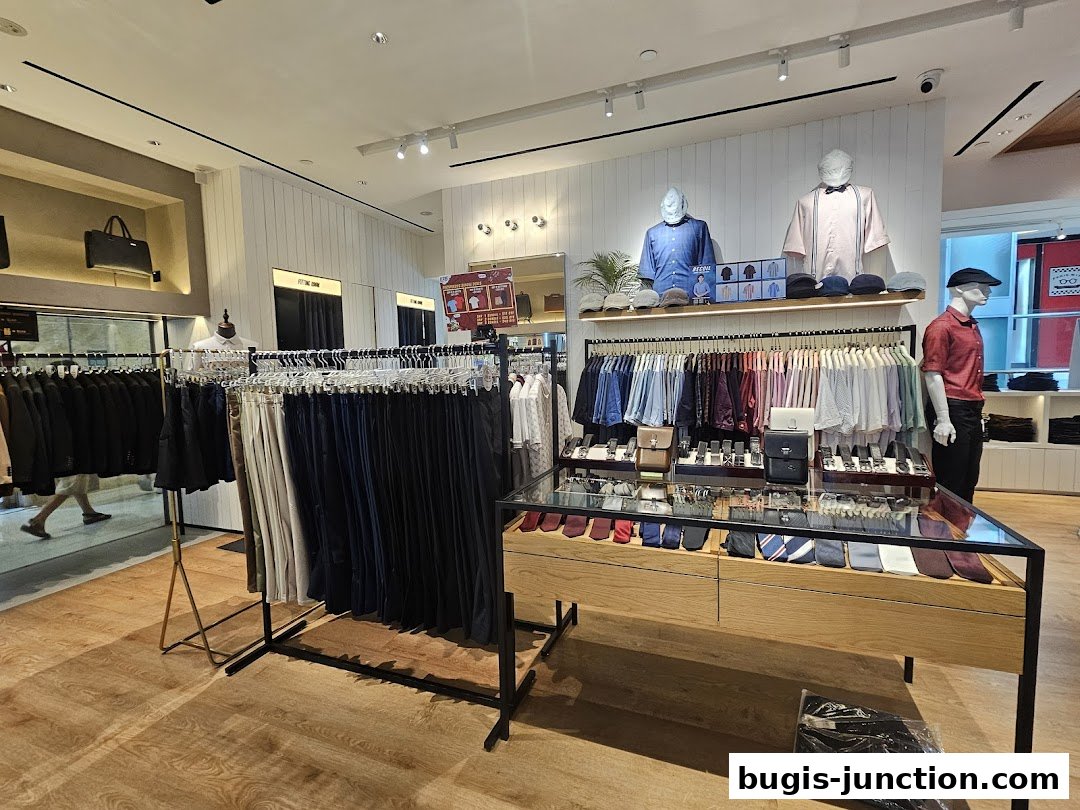 Interior view of a men's clothing store with racks of shirts, pants, ties, and accessories.