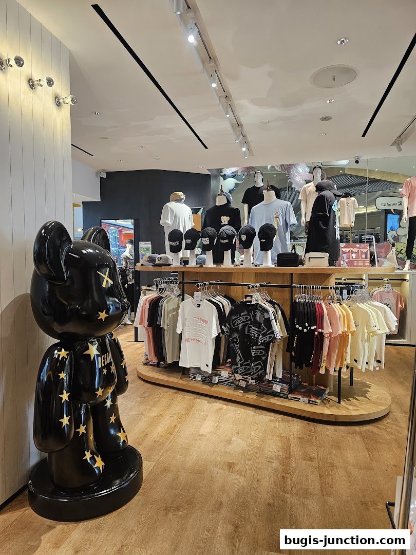 Interior view of RECOIL shop showcasing t-shirts and caps on display with a large black bear statue.