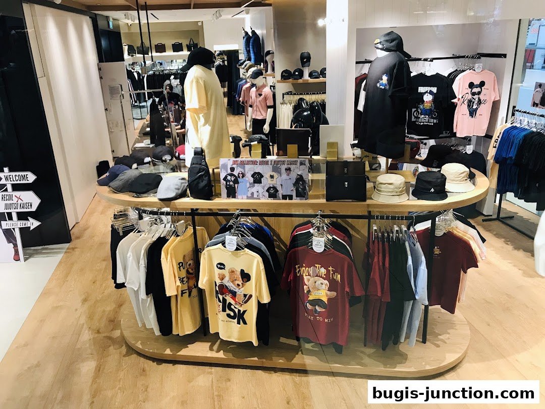 Interior view of RECOIL clothing store showcasing t-shirts, hats, and bags on display.
