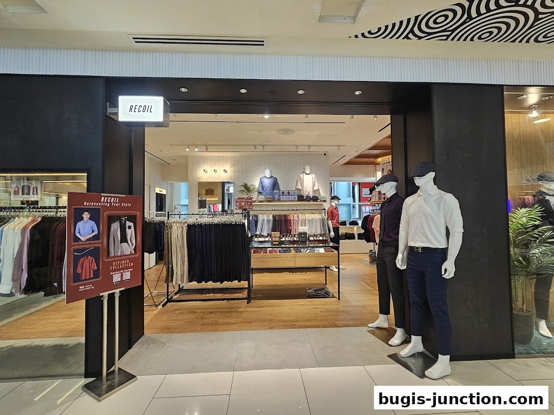 The entrance of RECOIL, a men's fashion store, showcasing mannequins and clothing displays.