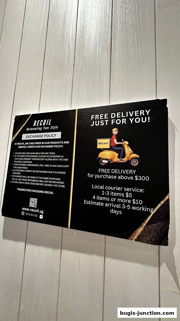 A sign detailing RECOIL's exchange policy and free delivery offer.