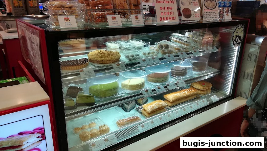 A display case filled with various pastries, cakes, and strudels from Ritz Apple Strudel.