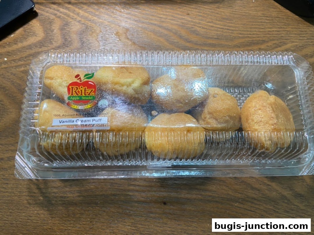A clear plastic container filled with golden-brown vanilla cream puffs.