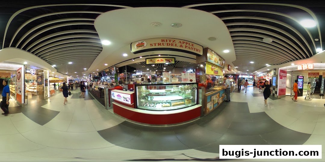 A panoramic view of Ritz Apple Strudel & Pastry shop and surrounding mall walkway.