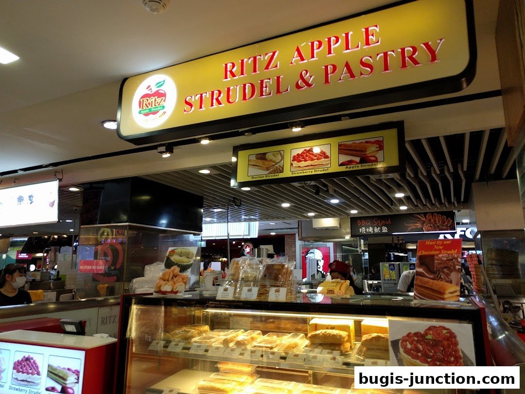 A Ritz Apple Strudel & Pastry shop with a display of pastries and a prominent sign.