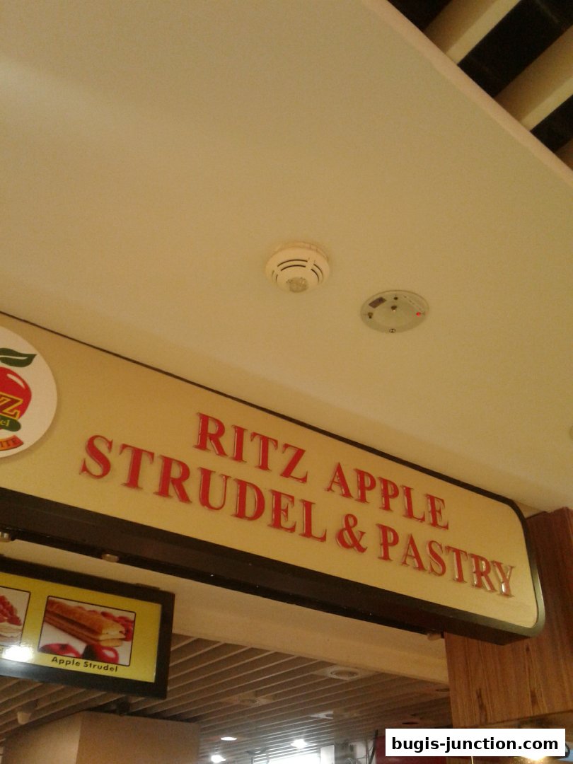 A sign for Ritz Apple Strudel & Pastry with an image of apple strudel.