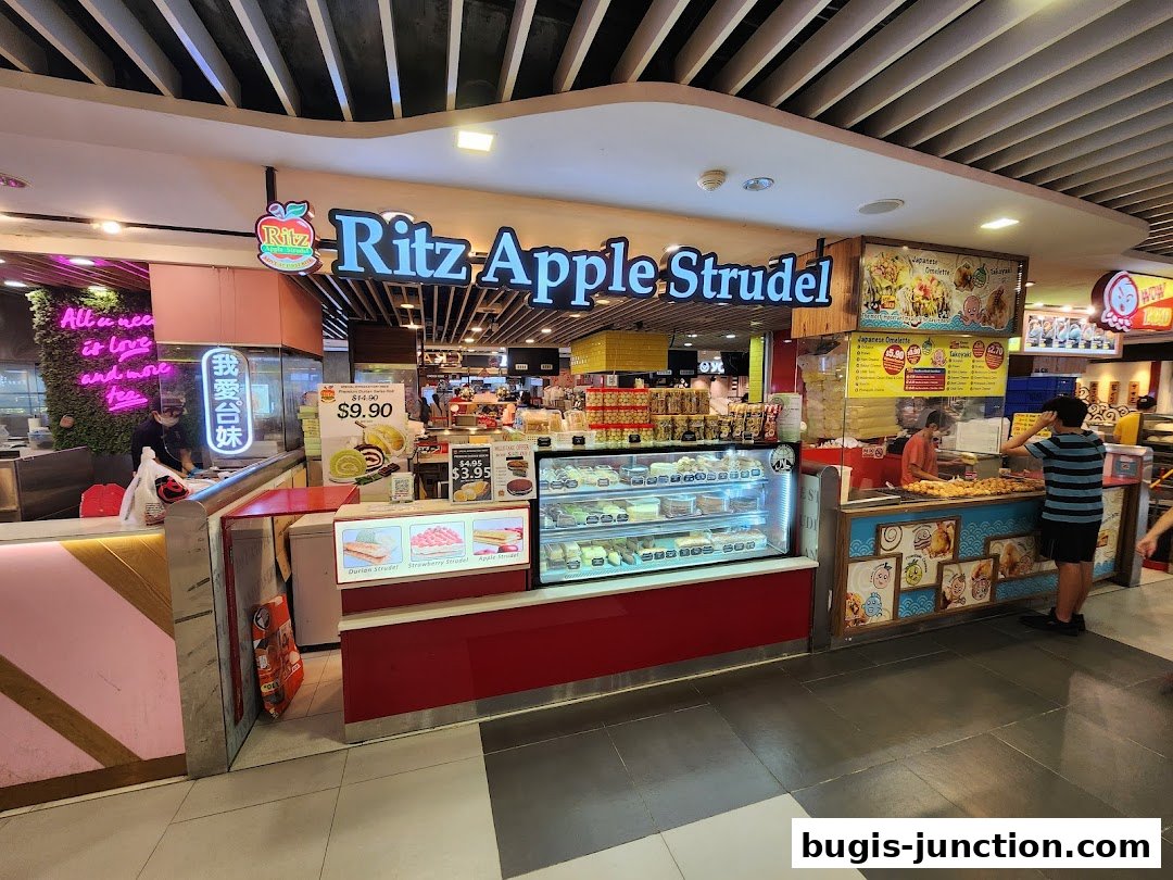 Ritz Apple Strudel shop front with display cases of pastries and a menu board.