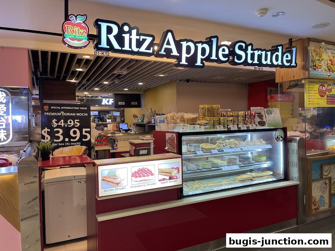 A Ritz Apple Strudel shop with a display of strudels and mochi, and a special offer sign.