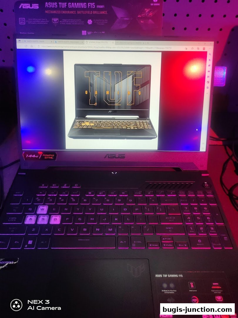 An ASUS TUF Gaming F15 laptop is displayed with its screen showing the laptop itself.