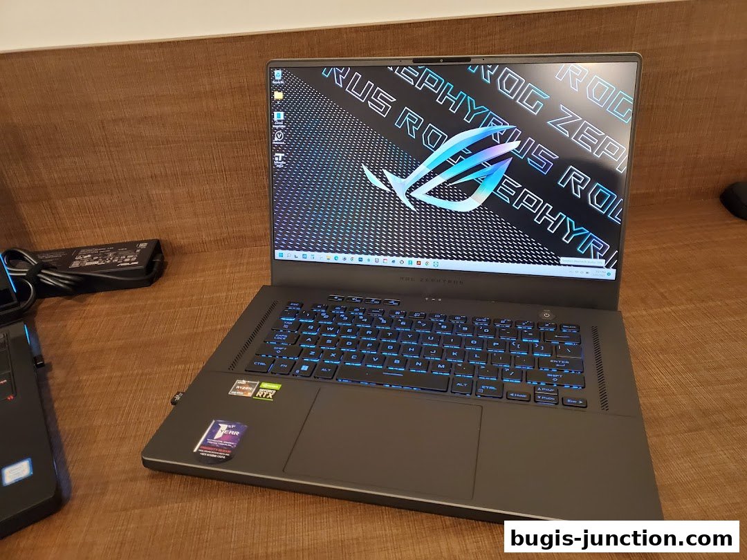 A close-up of an open ROG Zephyrus laptop with a glowing blue keyboard and ROG logo on the screen.