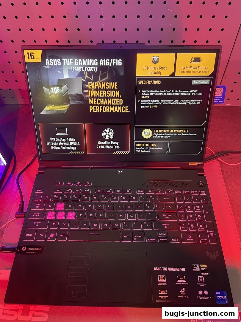 A close-up view of an ASUS TUF Gaming laptop with illuminated keyboard and product specifications displayed.
