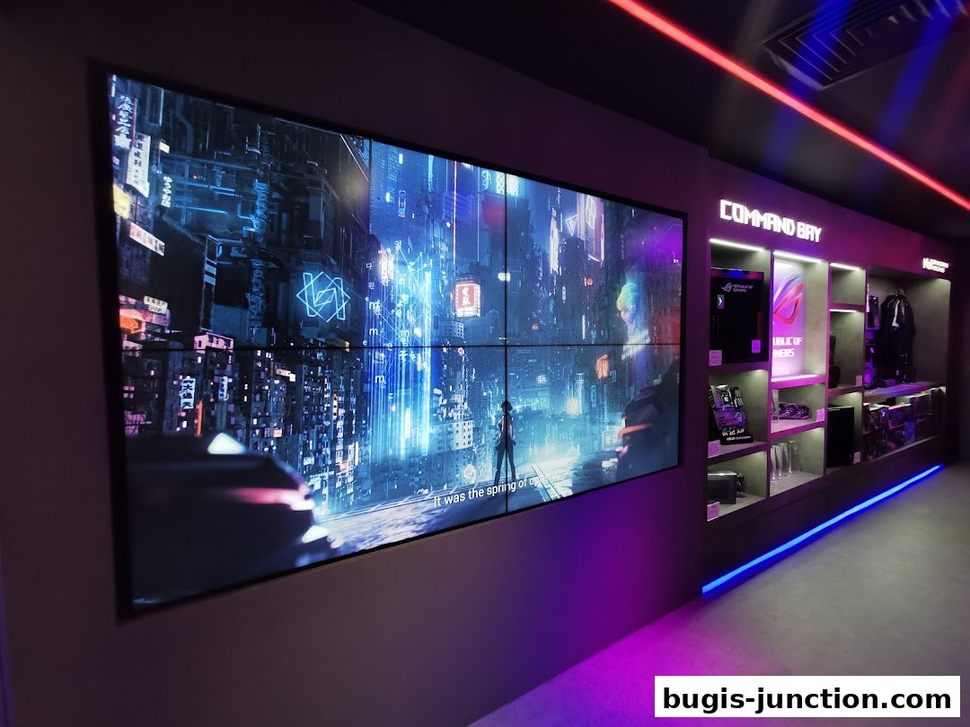 Interior of the ROG Experience Store with a large screen displaying futuristic cityscapes and shelves with gaming products.