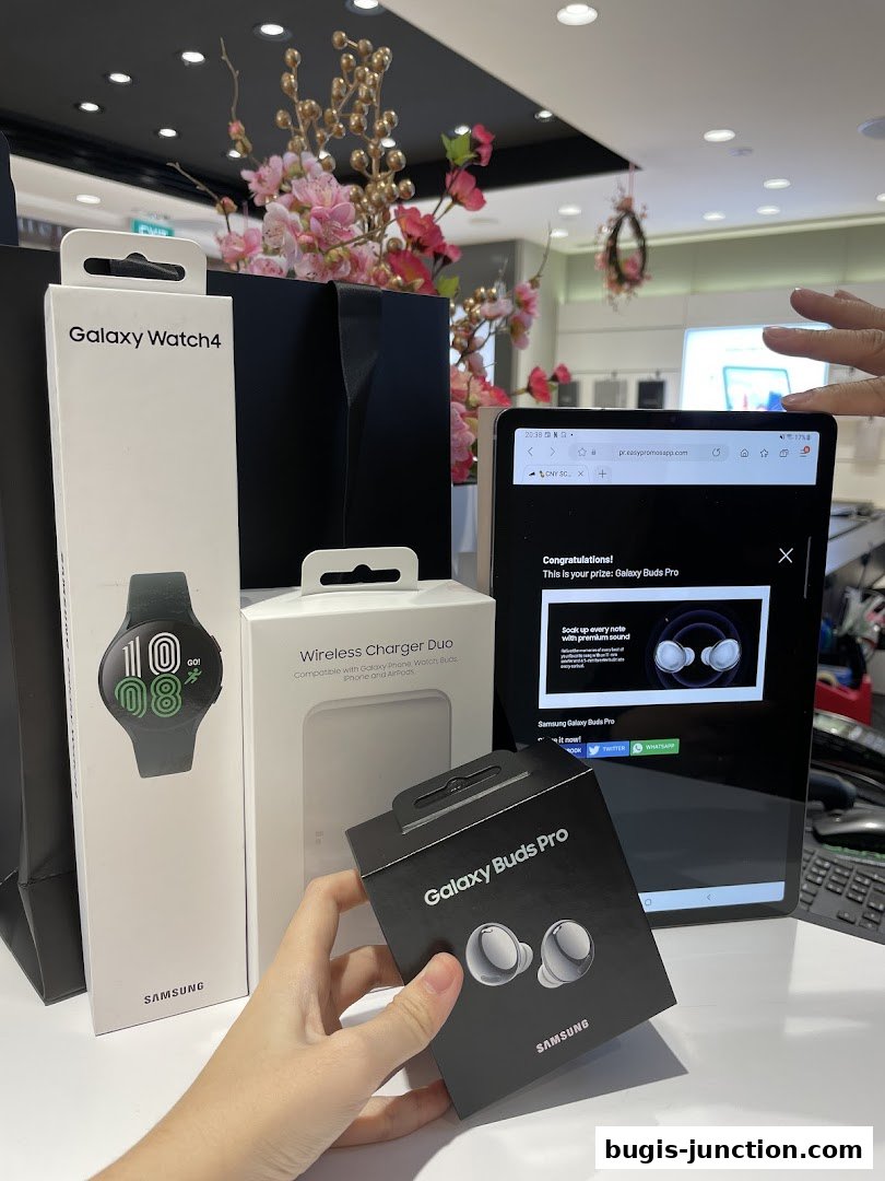 Samsung Galaxy products including a watch, wireless charger, and earbuds are displayed.