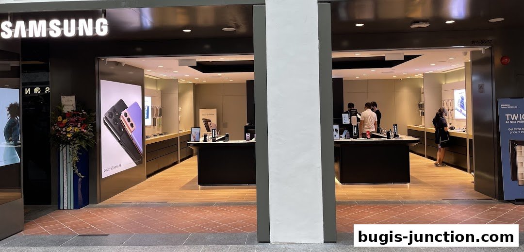 The entrance of a Samsung Experience Store with displays of phones and staff assisting customers.