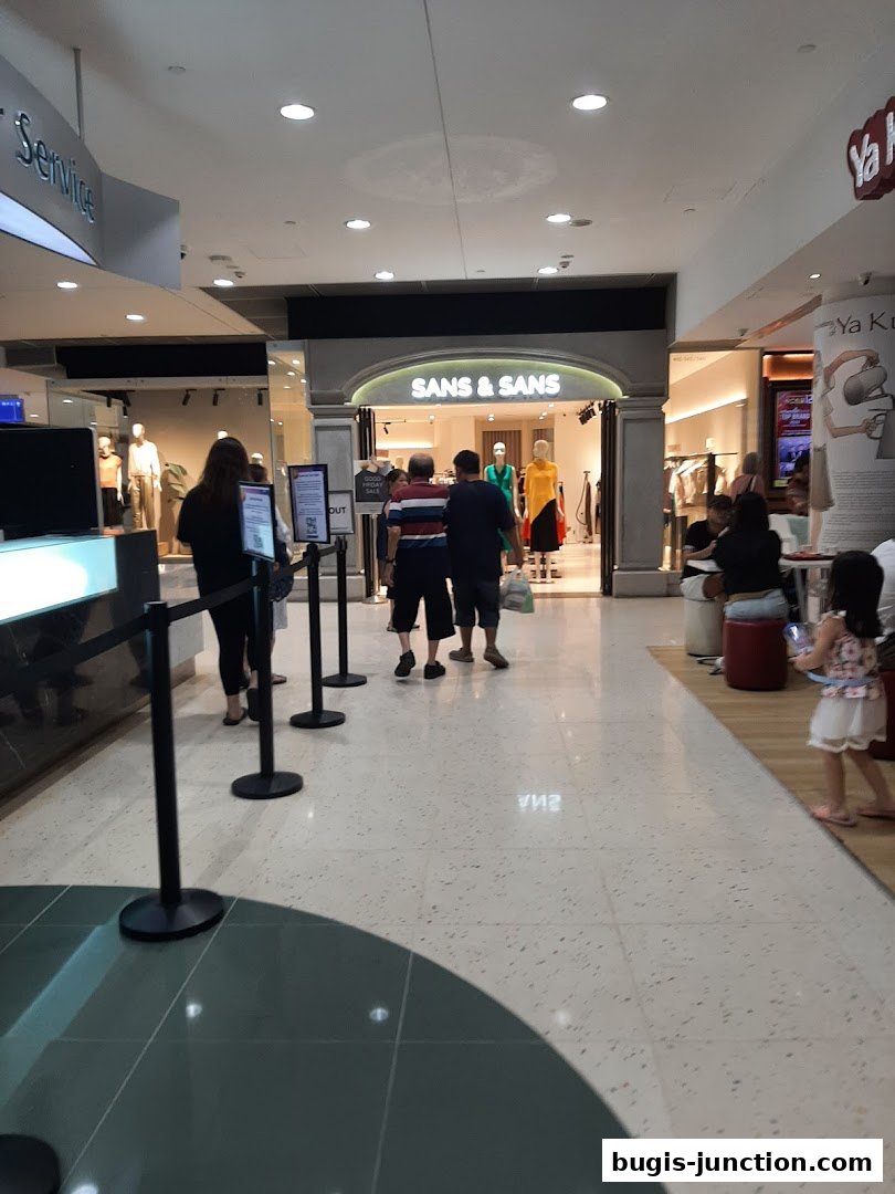 The entrance of SANS & SANS clothing store with mannequins displaying outfits.