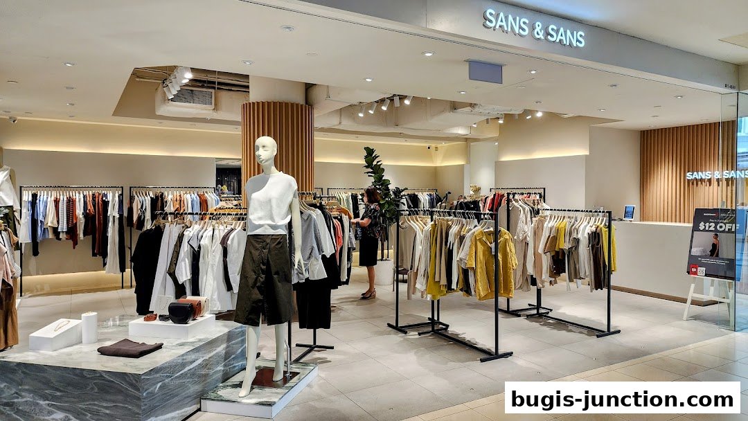 Interior view of a modern clothing store with mannequins and racks of apparel.