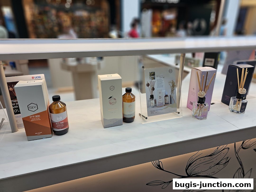 A display of various scented reed diffusers and bottled fragrances from the Scent by SIX brand.