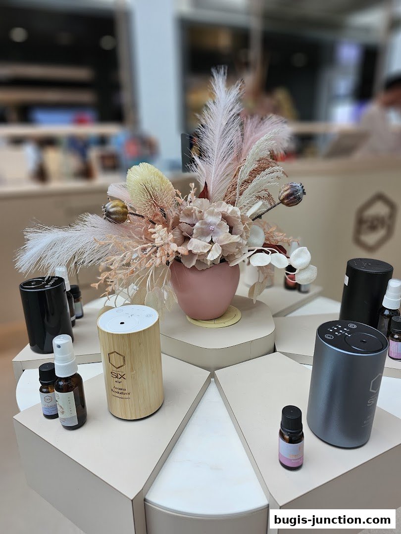 A display of aroma diffusers and essential oils with a decorative floral arrangement.
