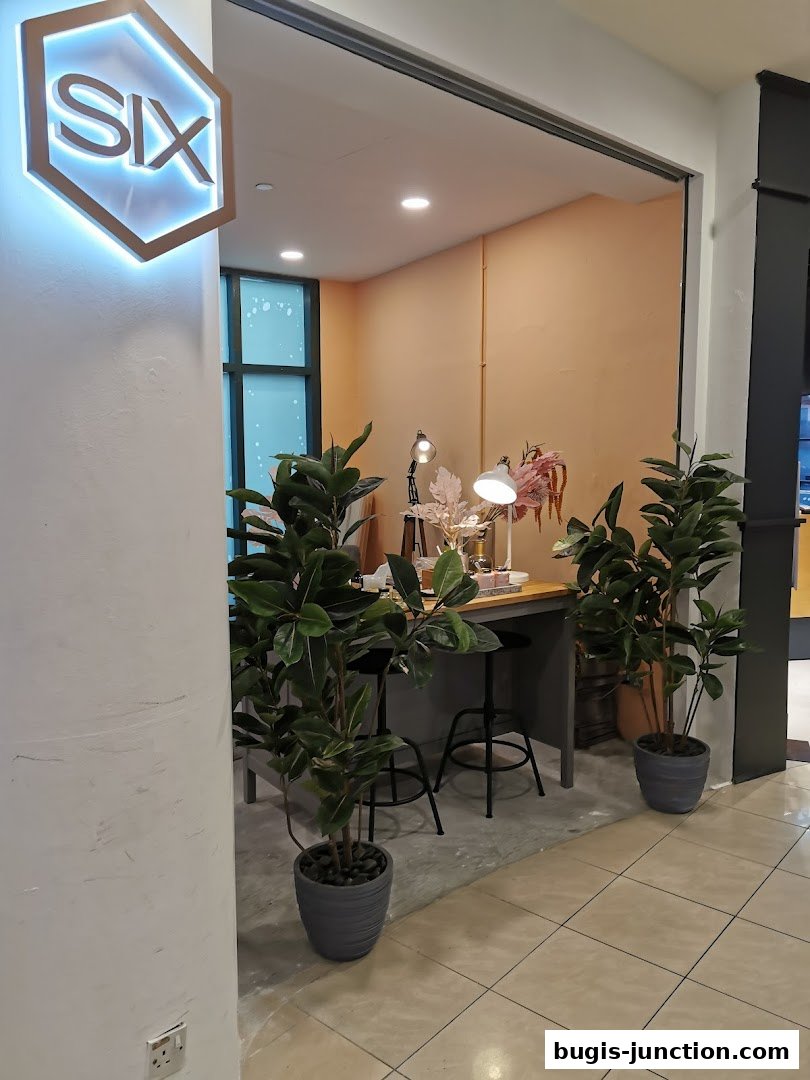 A shop interior with plants, lamps, and a counter displaying various items.
