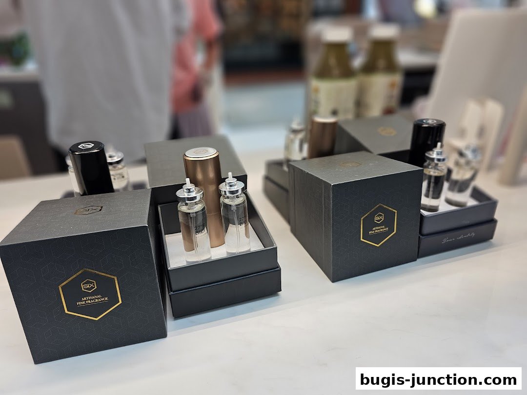 A display of artisanal fine fragrance bottles and gift boxes on a white surface.