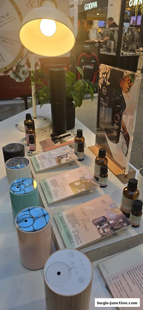 A display of diffusers and essential oils with promotional flyers and a lamp.